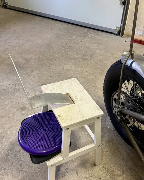 The seat pan resting on a stool beside the bike