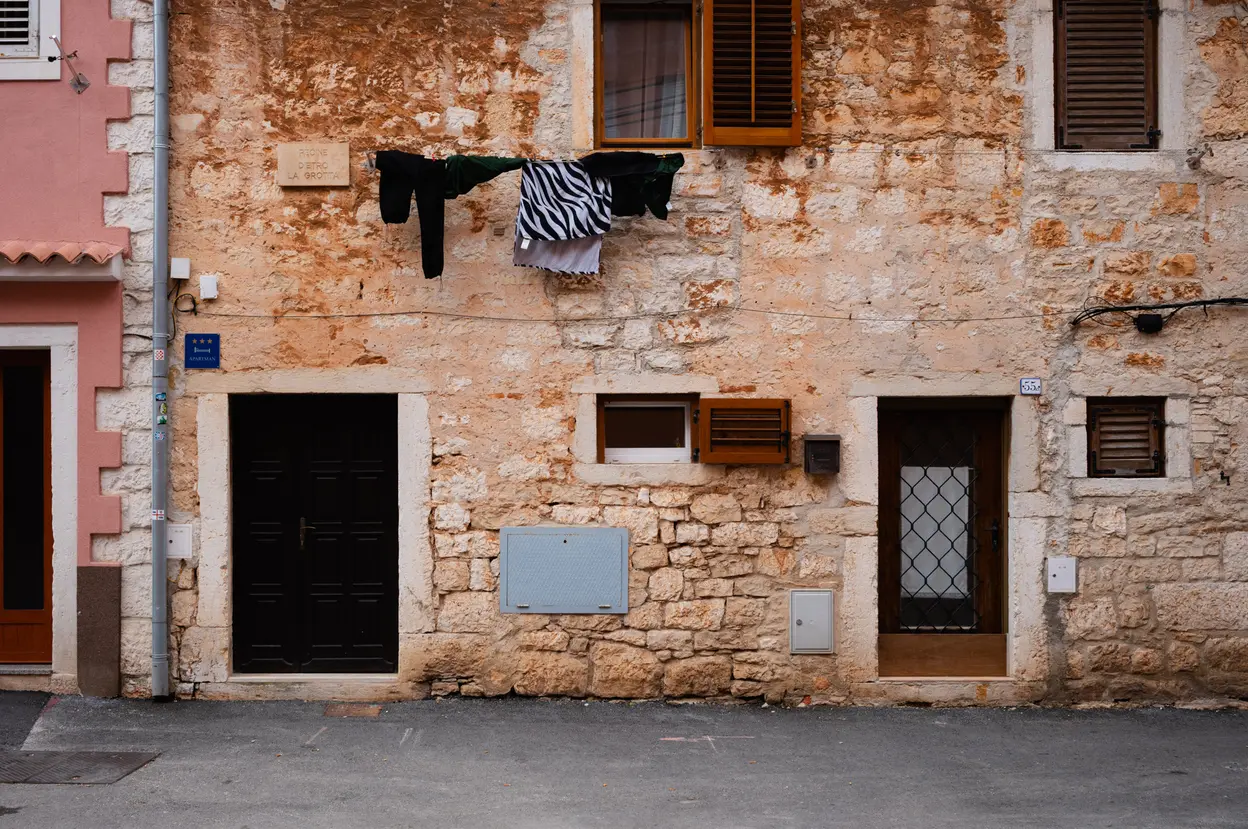 Laundry on a line strung across the front of a stone house